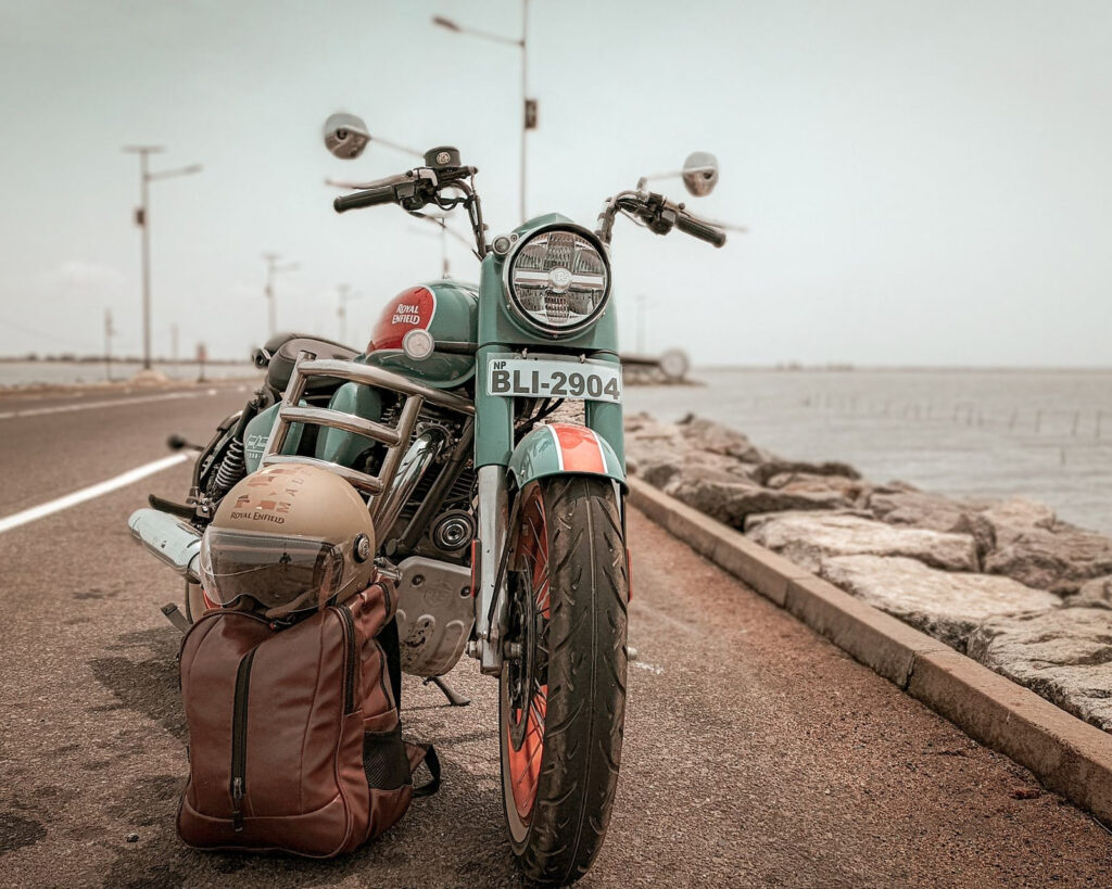 A touring motorcycle loaded with luggage parked on a coastal road