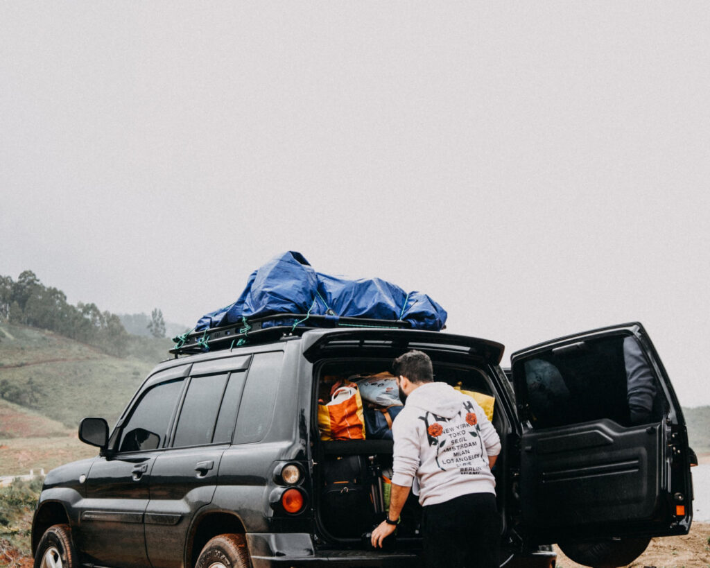 Bags being loaded into the back of a four-wheel drive at the start of a trip
