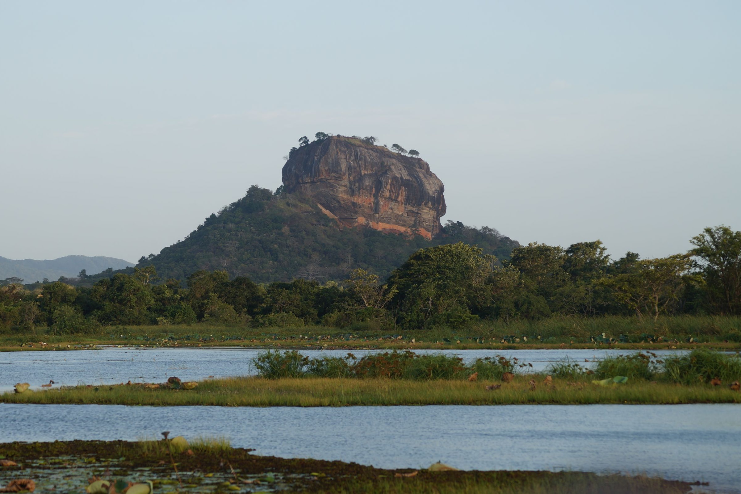 Sigiriya rock rising above a lake in Sri Lanka's cultural triangle