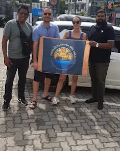Guests holding the Tour Ceylon +94 banner in the street