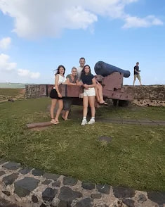 Guests sitting on a cannon on the ramparts at Galle Fort