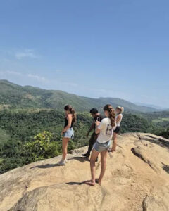 Guests on a rock outlook above the hills