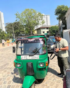 A three-wheeler waiting on a city street